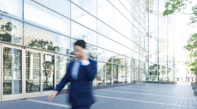 早い足並みで歩くビジネスマン